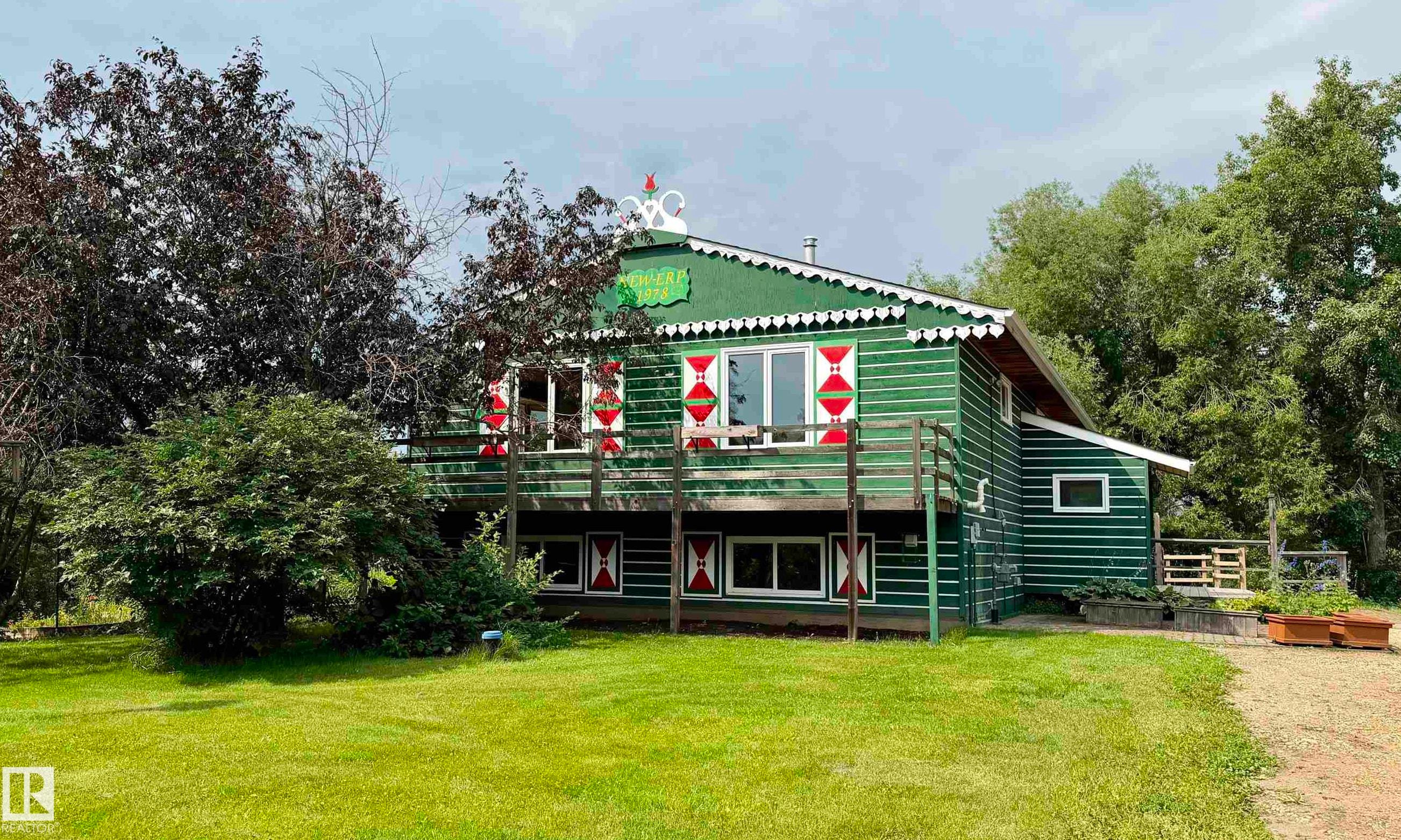 Green-sided home with a prominent second-story balcony featuring wood railings - 54046 Rge Road 213, Rural Strathcona County, AB - Outdoor