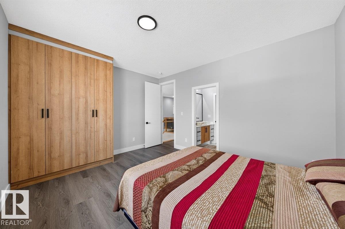 Built-in wood-finish wardrobe with contemporary black handles - 6001 19 Street, Nisku, AB - Indoor Photo Showing Bedroom