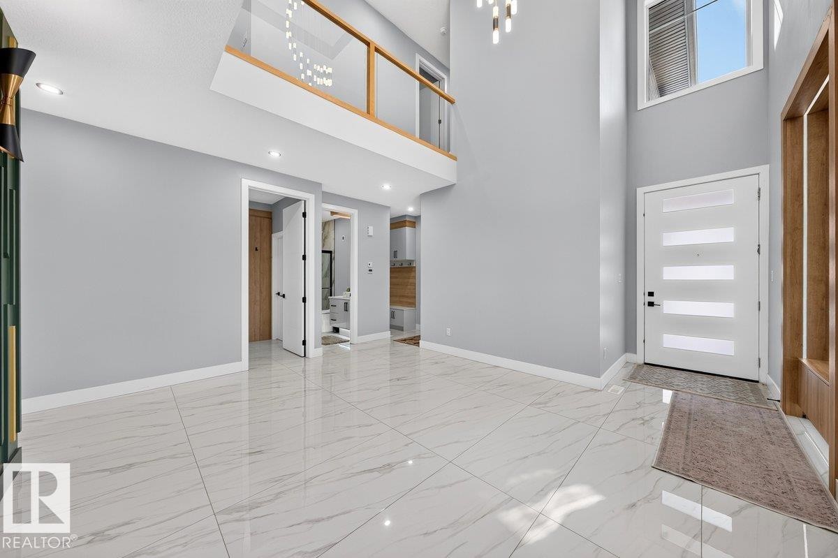 Two-story entryway featuring high ceilings, large format tile flooring, and a contemporary light fixture - 6001 19 Street, Nisku, AB - Indoor Photo Showing Other Room
