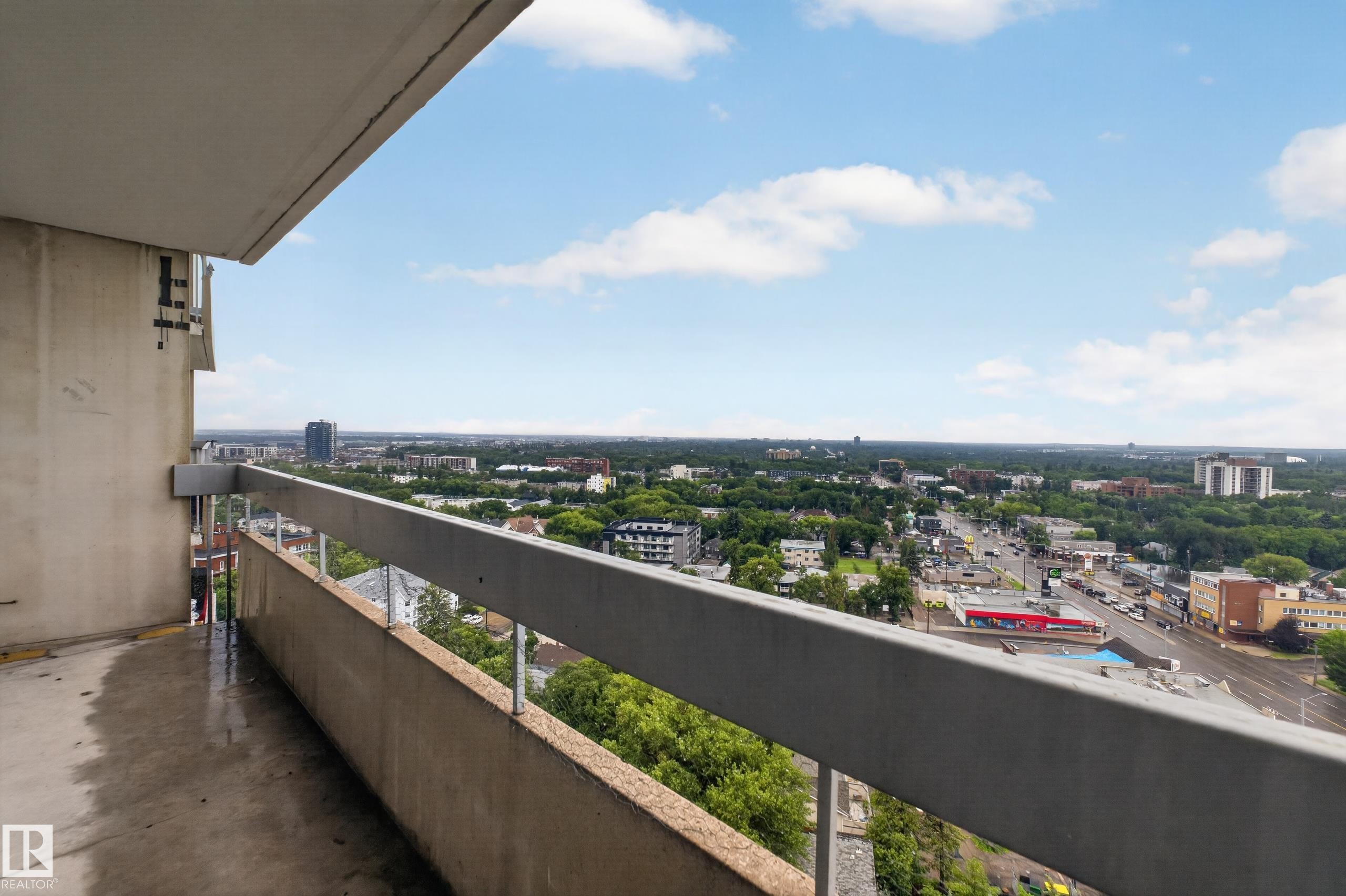 Expansive balcony with concrete flooring, a solid railing, and widespread urban and treeline scenery - #1804 10883 Saskatchewan Dr Nw, Edmonton, AB - Outdoor With Balcony With View