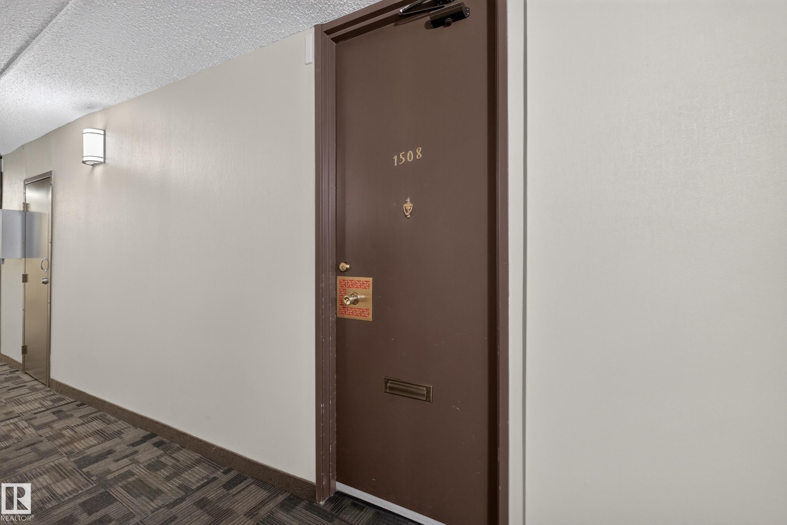 Entry door with brass hardware, featuring a mail slot and visible unit number - #1508 10883 Saskatchewan Dr Nw Nw, Edmonton, AB - Indoor