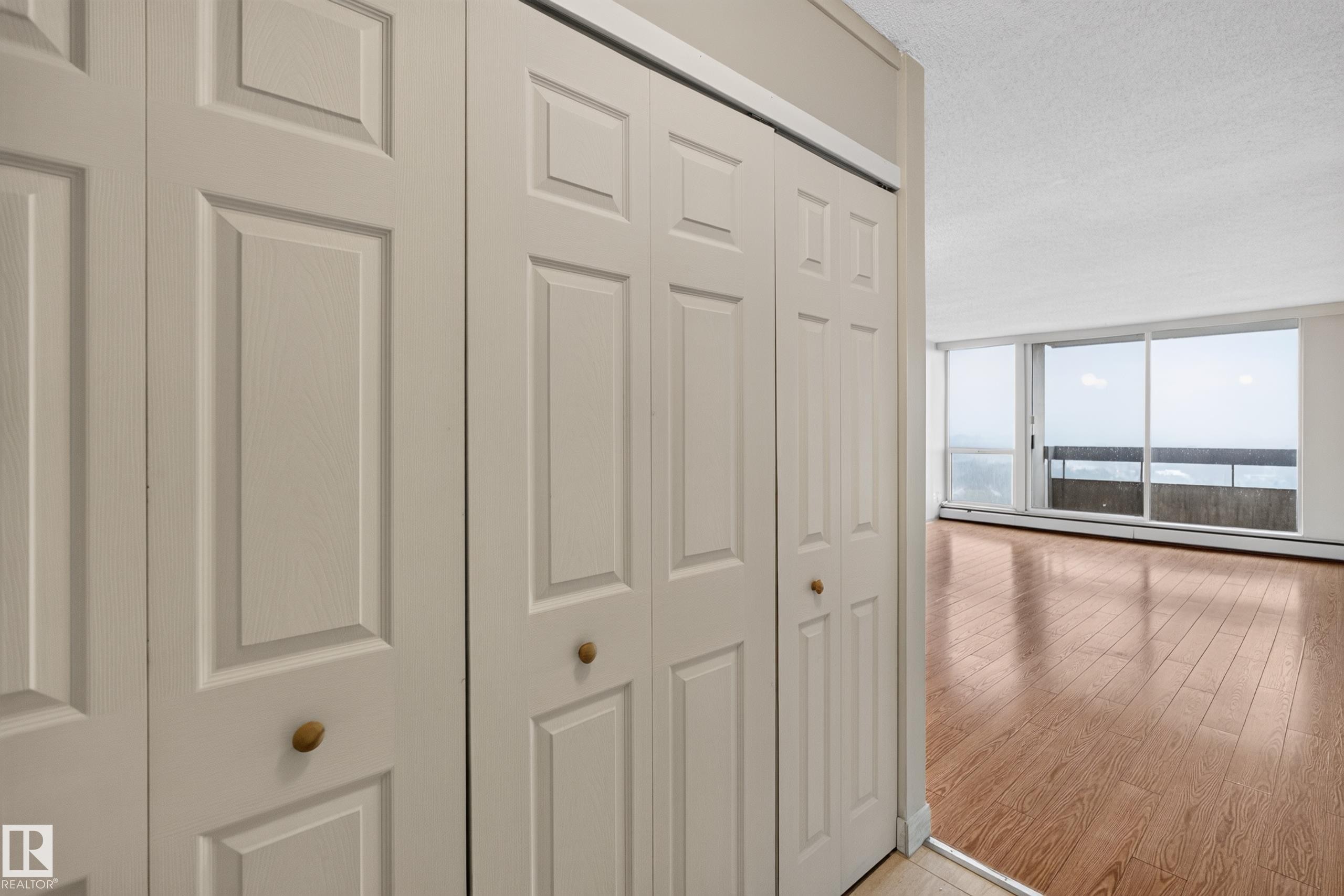 Bifold closet doors with brass-finish knobs providing storage - #1508 10883 Saskatchewan Dr Nw Nw, Edmonton, AB - Indoor Photo Showing Other Room
