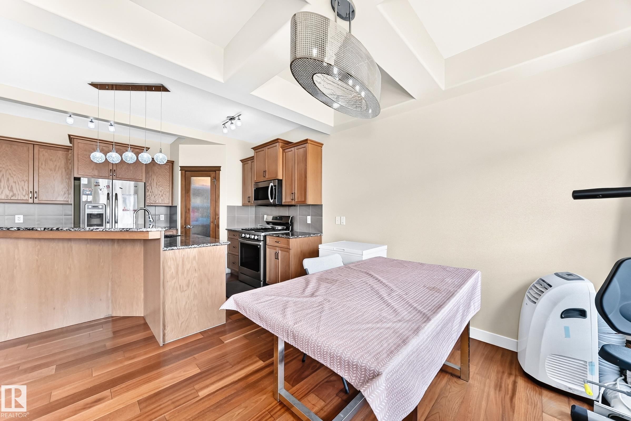 Kitchen featuring stainless steel appliances, wood cabinetry, granite countertops, and a tile backsplash - 2923 16 Street Nw, Edmonton, AB - Indoor
