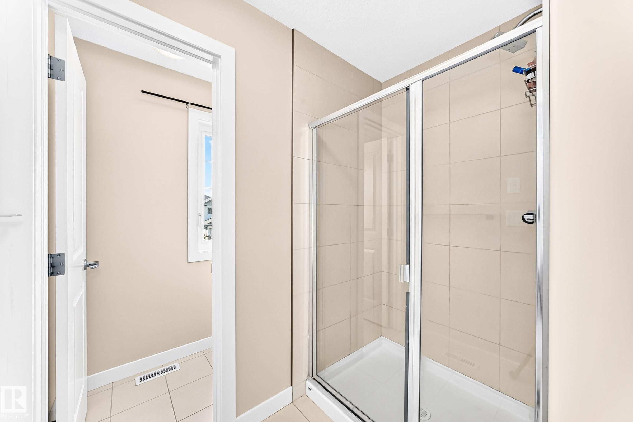 Glass-enclosed shower with a tiled surround, chrome fixtures, and a white shower pan - 2923 16 Street Nw, Edmonton, AB - Indoor Photo Showing Bathroom