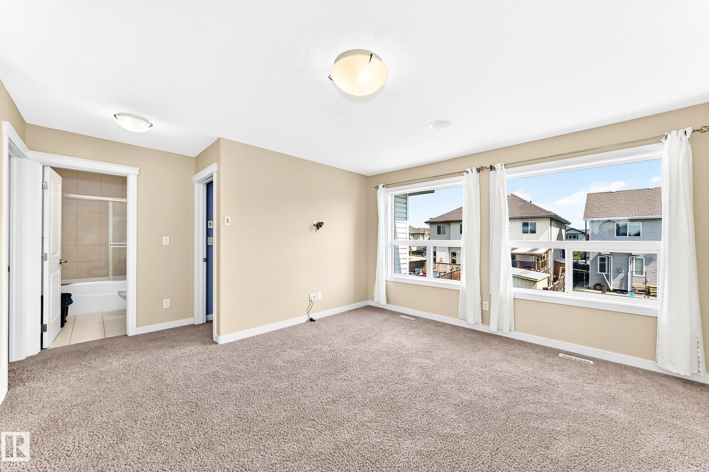 Spacious room featuring broadloom carpet flooring and multiple large windows - 2923 16 Street Nw, Edmonton, AB - Indoor Photo Showing Other Room