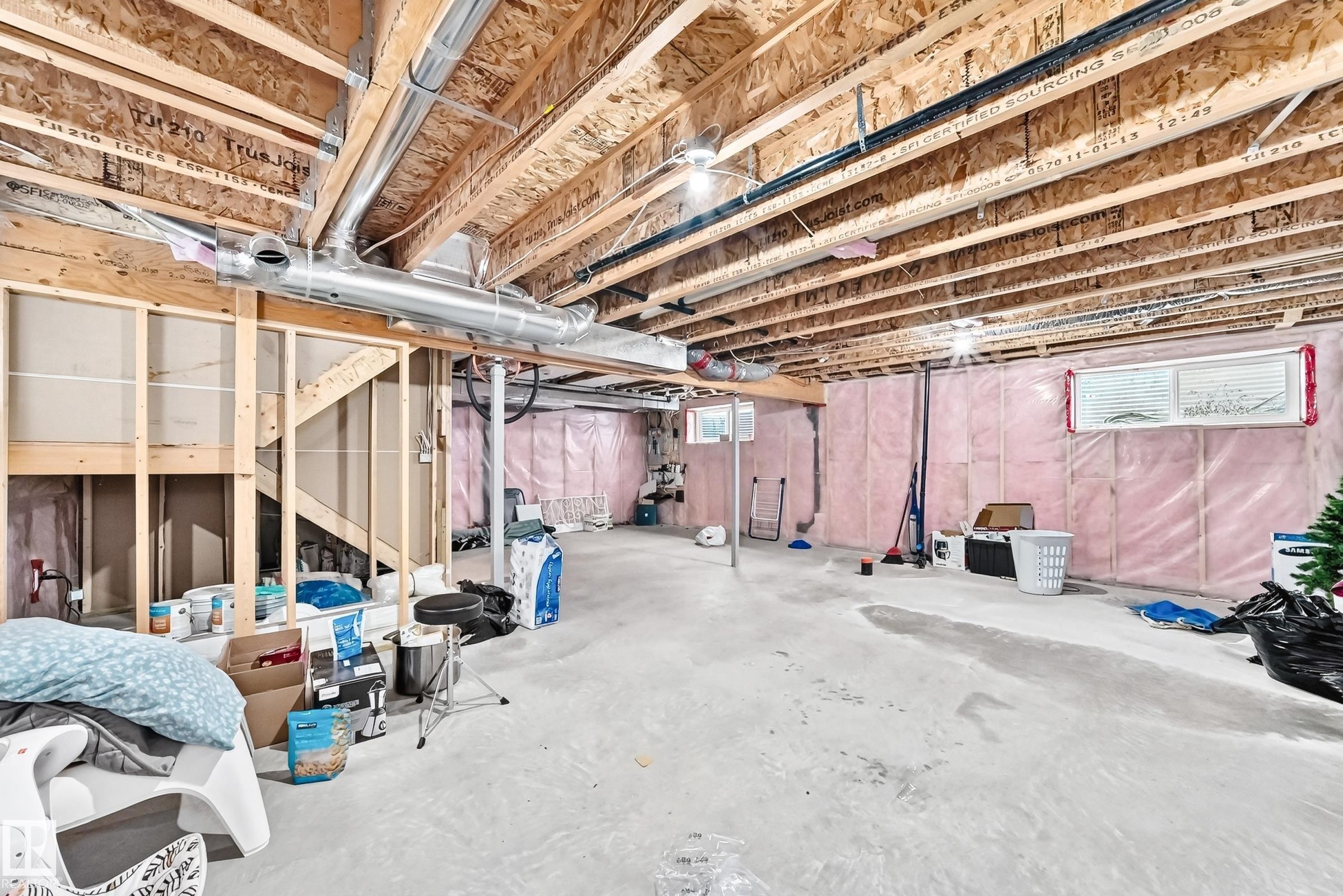 Unfinished basement featuring exposed wood joists, concrete flooring, perimeter insulation, and visible framing for future development - 2923 16 Street Nw, Edmonton, AB - Indoor Photo Showing Basement