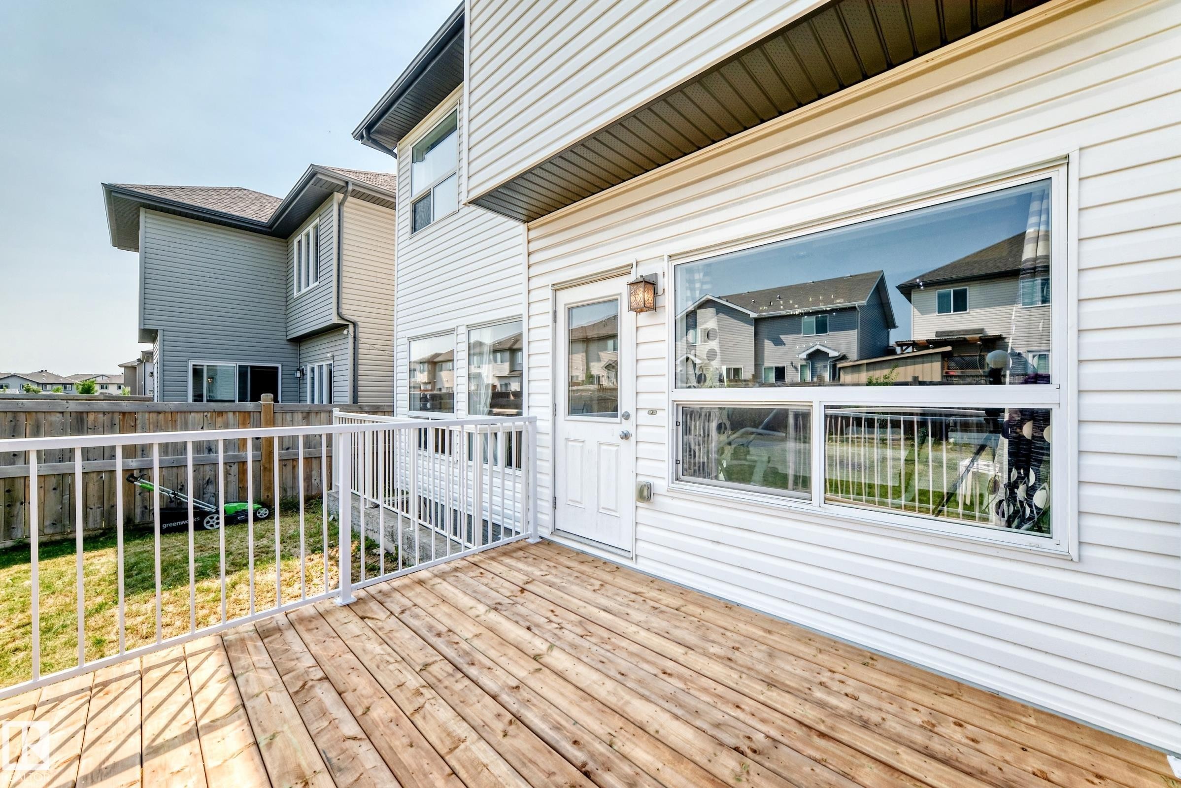 Exterior wood deck with white metal railings, white vinyl siding, and a white exterior door - 2923 16 Street Nw, Edmonton, AB - Outdoor With Deck Patio Veranda With Exterior