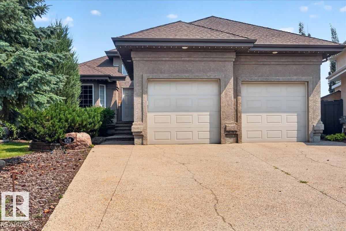 Stucco exterior with a two-car garage and concrete driveway - 928 Thompson Place Nw, Edmonton, AB - Outdoor