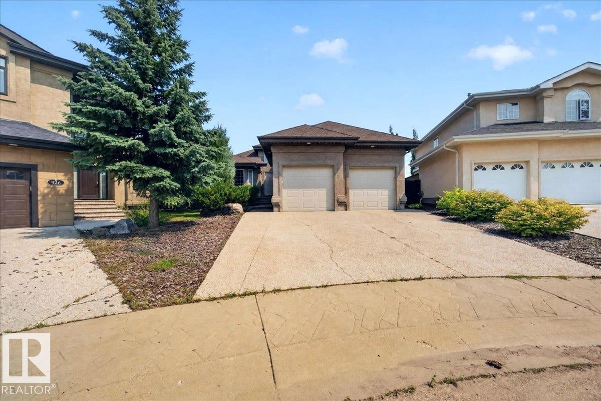 Stucco exterior with a two-car garage and concrete driveway - 928 Thompson Place Nw, Edmonton, AB - Outdoor
