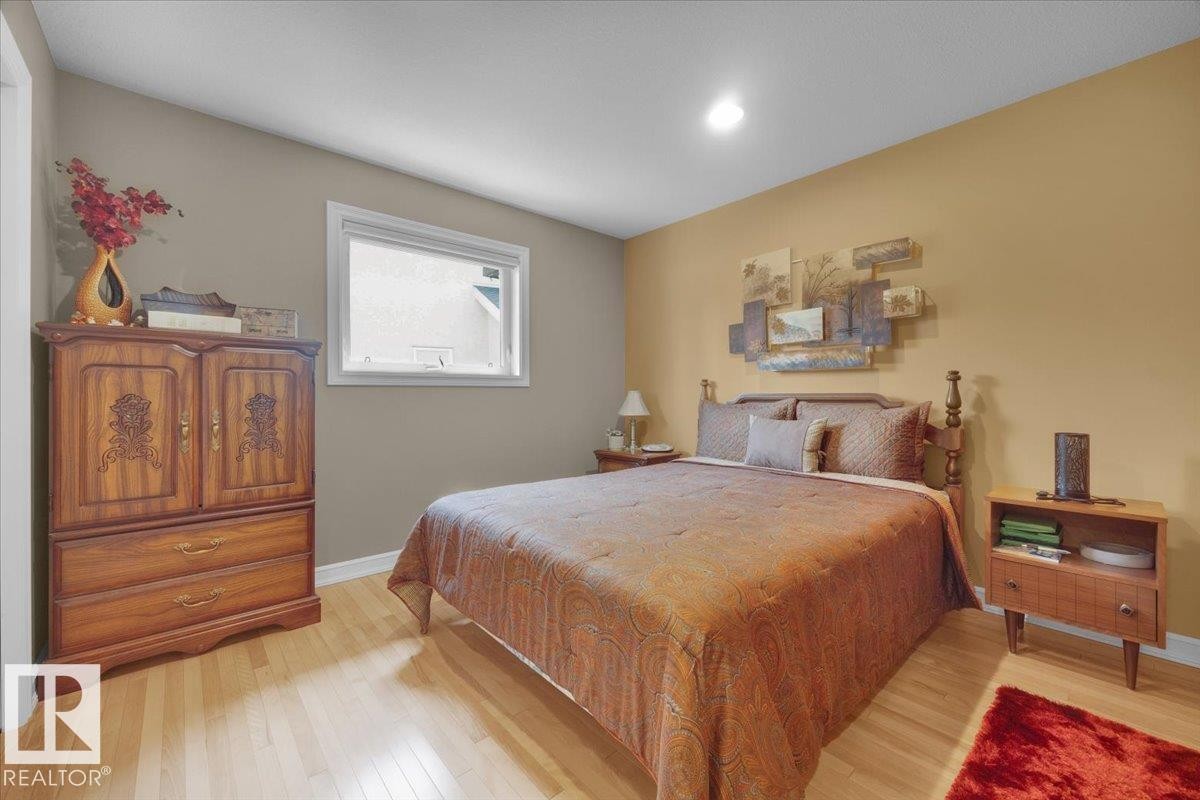 Bright room featuring light wood-finish flooring, a white-framed window, and neutral wall tones - 928 Thompson Place Nw, Edmonton, AB - Indoor Photo Showing Bedroom