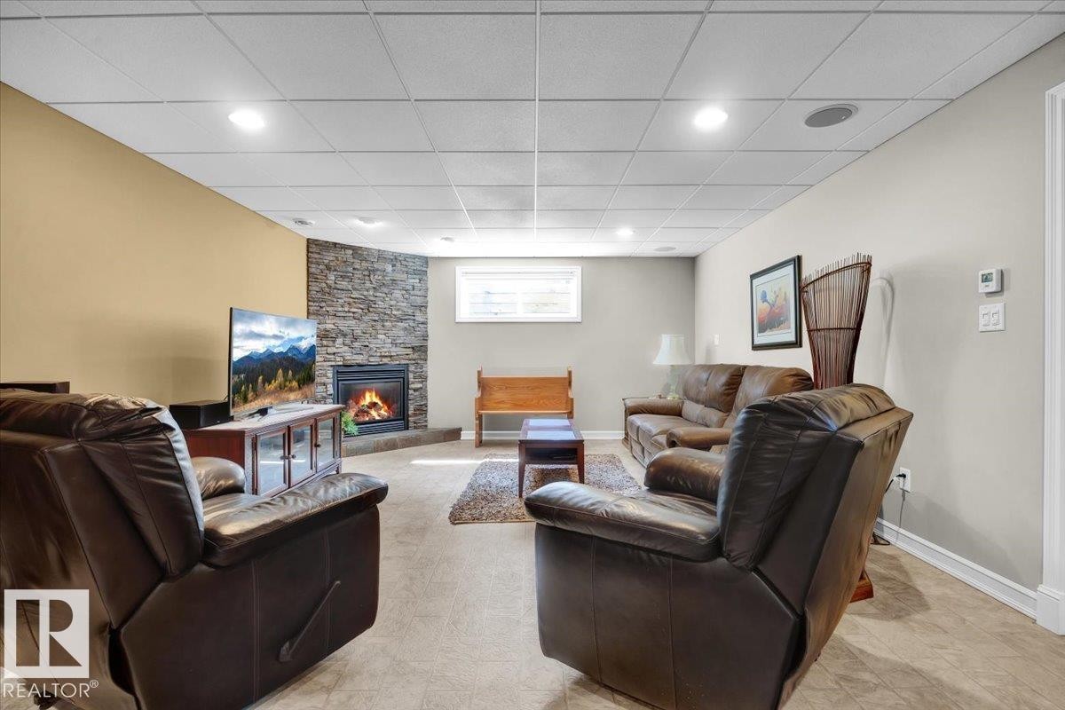 Corner fireplace with a stone surround - 928 Thompson Place Nw, Edmonton, AB - Indoor With Fireplace