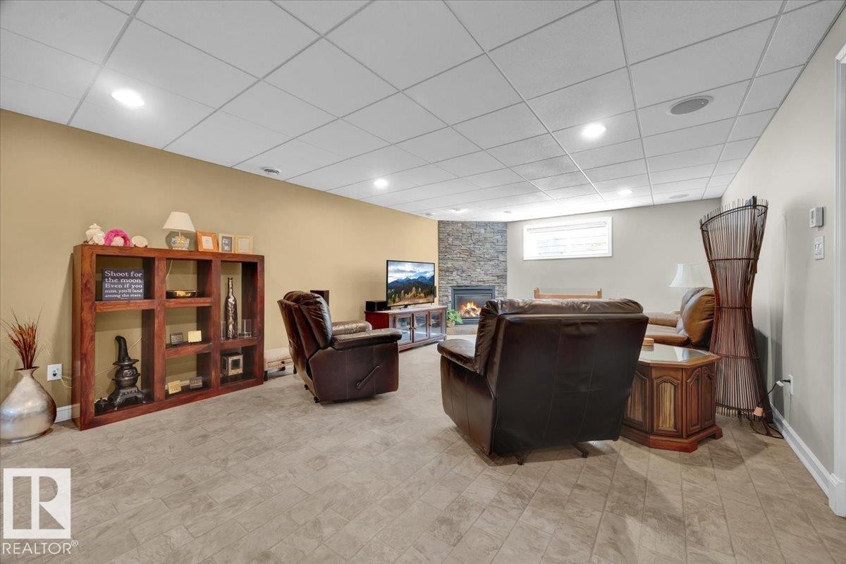 Spacious interior featuring neutral wall tones, recessed lighting, drop ceiling, and wood-finish flooring - 928 Thompson Place Nw, Edmonton, AB - Indoor