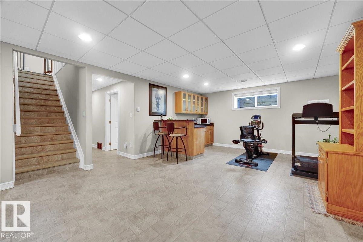 Lower level recreation space featuring tile-finish flooring, recessed lighting, and a drop ceiling - 928 Thompson Place Nw, Edmonton, AB - Indoor