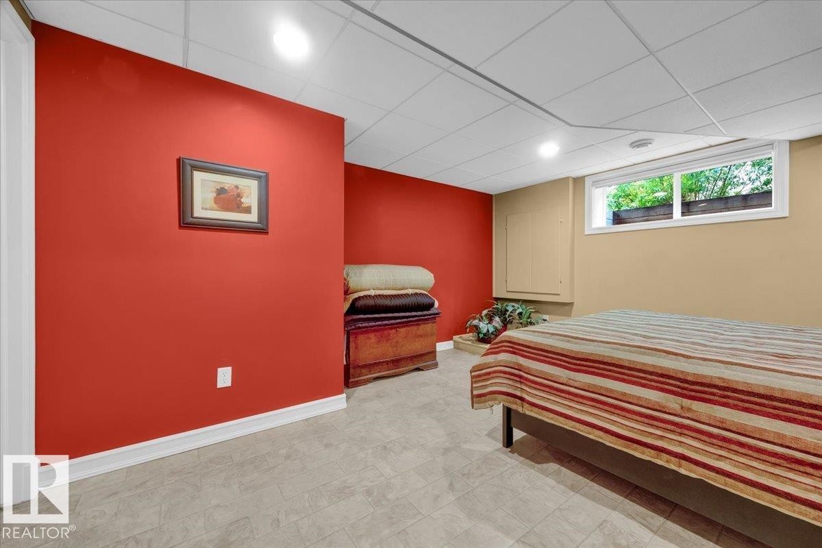 Finished room featuring a drop ceiling with recessed lighting, light-toned tile flooring, and a window with exterior greenery visible - 928 Thompson Place Nw, Edmonton, AB - Indoor Photo Showing Bedroom