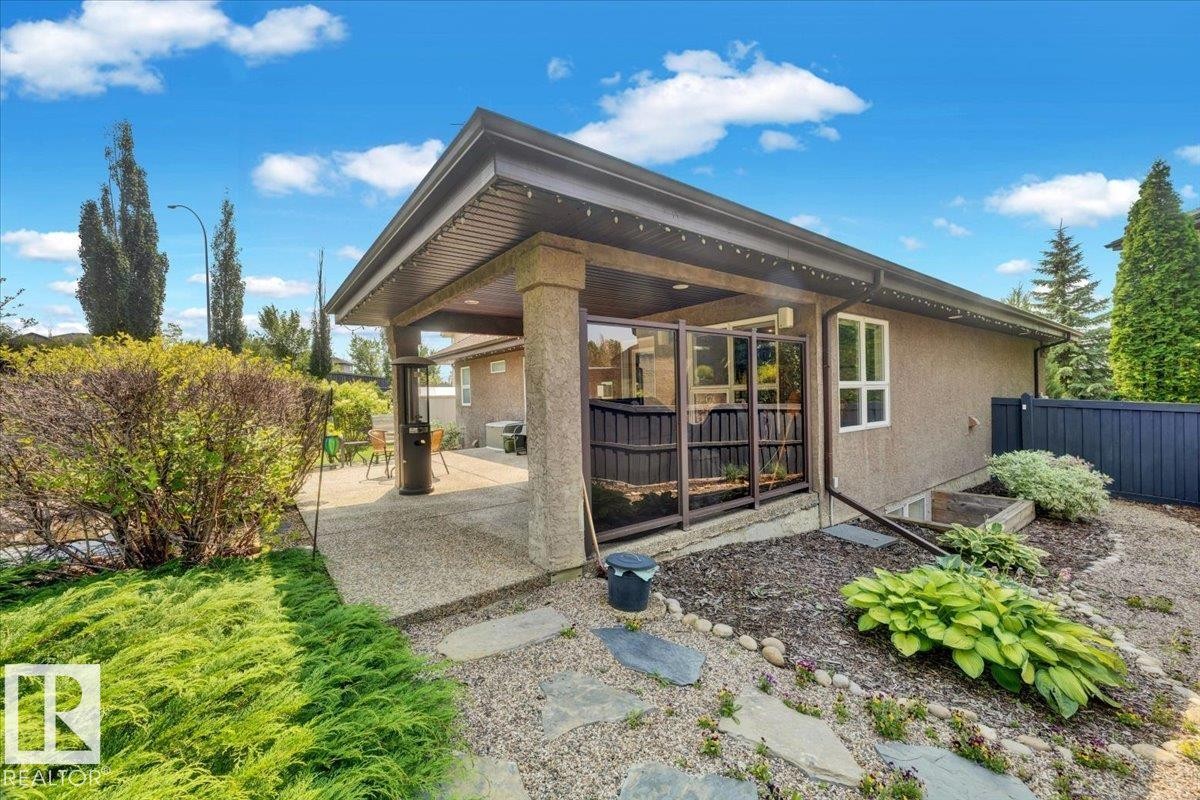 Expansive concrete patio beneath a covered pergola with a stucco exterior - 928 Thompson Place Nw, Edmonton, AB - Outdoor
