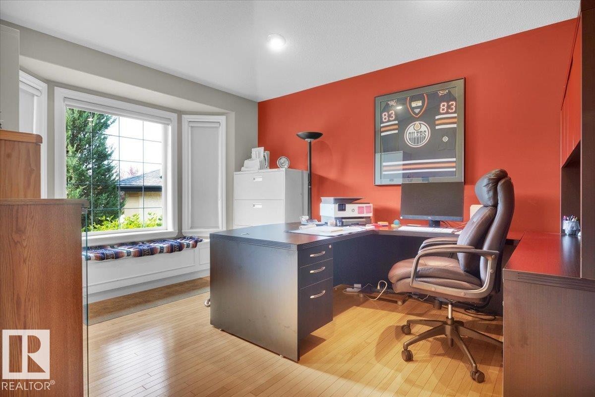 Flexible-use room featuring a bay window with integrated seating, hardwood flooring, and a built-in L-shaped desk with integrated storage - 928 Thompson Place Nw, Edmonton, AB - Indoor Photo Showing Office