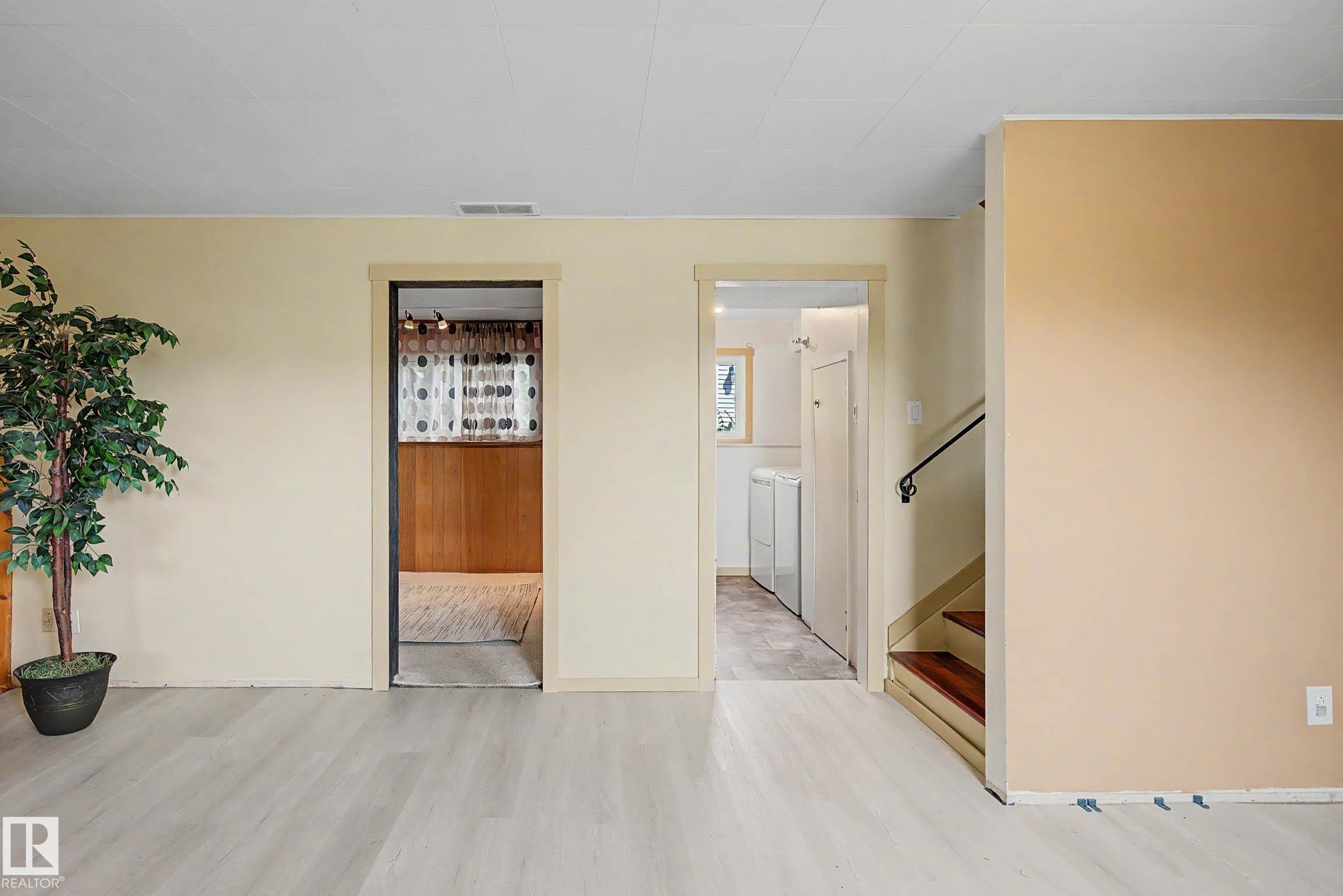 Light wood-finish flooring throughout the space - 9516 129A Avenue Nw, Edmonton, AB