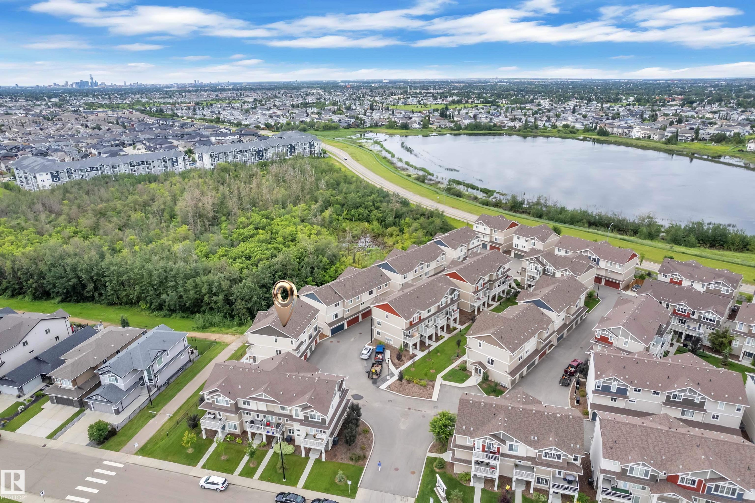 Aerial perspective showcasing a residential community with townhomes and detached properties - #64 17832 78 St Nw Nw, Edmonton, AB - Outdoor With Body Of Water With View