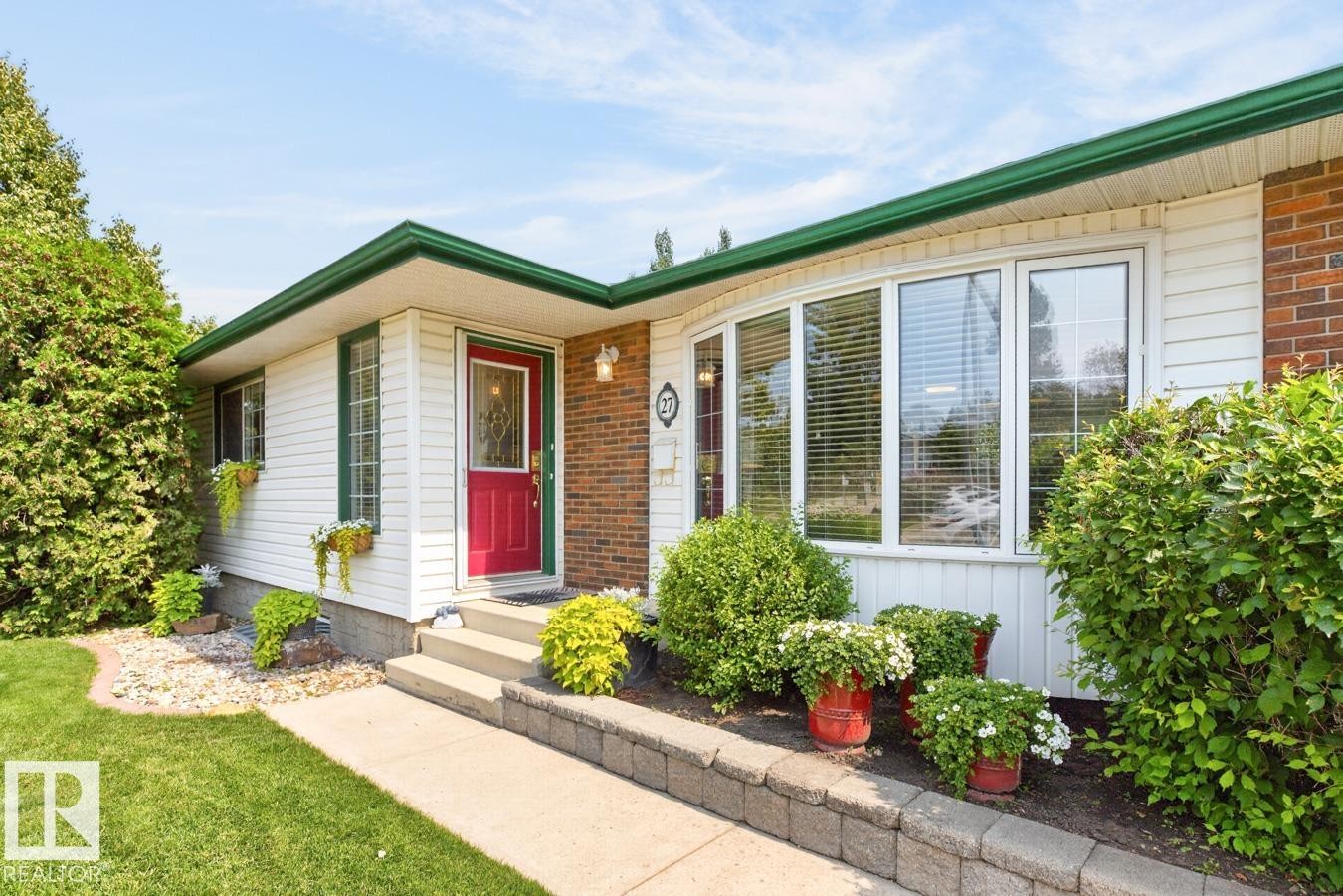 White siding exterior with brick accents, featuring a prominent red entry door - 27 Milford Crescent, Sherwood Park, AB - Outdoor