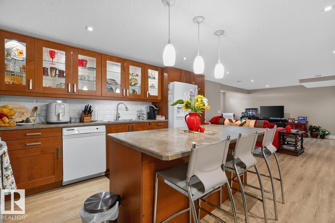 Kitchen island with integrated breakfast bar seating, featuring a stone-finish countertop - 27 Milford Crescent, Sherwood Park, AB - Indoor