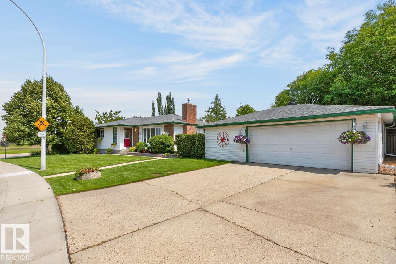 Ranch-style residence featuring a prominent red entry door, white siding, and a brick chimney - 27 Milford Crescent, Sherwood Park, AB - Outdoor