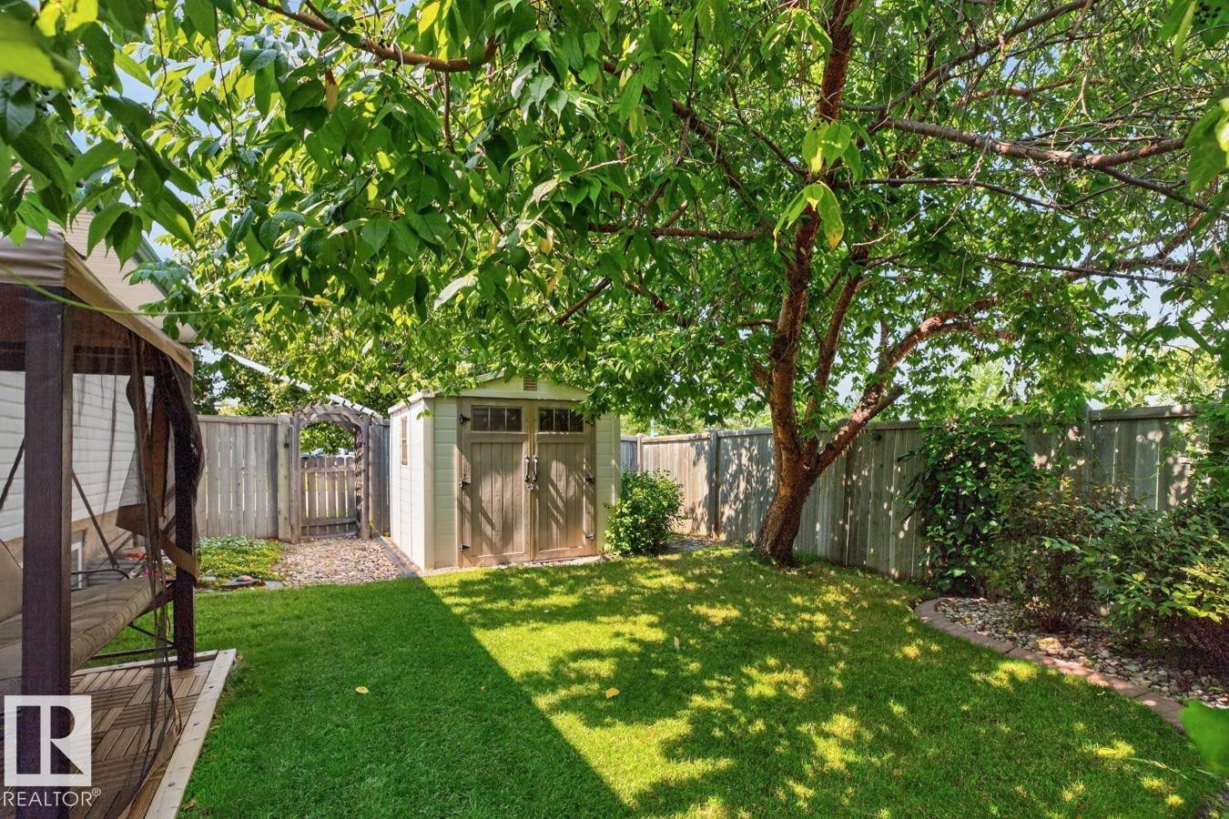 Fenced backyard featuring a manicured lawn and mature shade trees - 27 Milford Crescent, Sherwood Park, AB - Outdoor