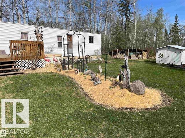 Manicured lawn with a decorative wood chip bed - 210 55504 Nikoodi Road, Rural Lac Ste. Anne County, AB - Outdoor