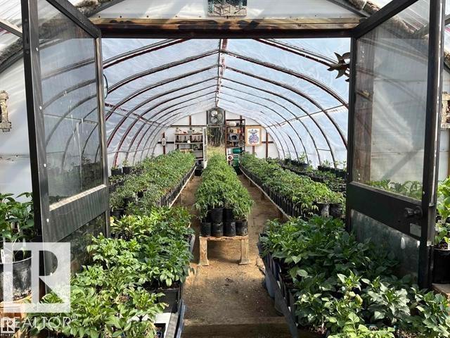 Spacious hoop-style greenhouse featuring a translucent arched roof, dual entry doors, multiple planting beds, and an exhaust fan - 210 55504 Nikoodi Road, Rural Lac Ste. Anne County, AB - Outdoor