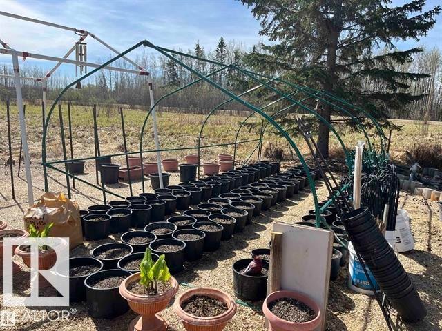 Outdoor greenhouse frame structure with rows of planting pots - 210 55504 Nikoodi Road, Rural Lac Ste. Anne County, AB - Outdoor