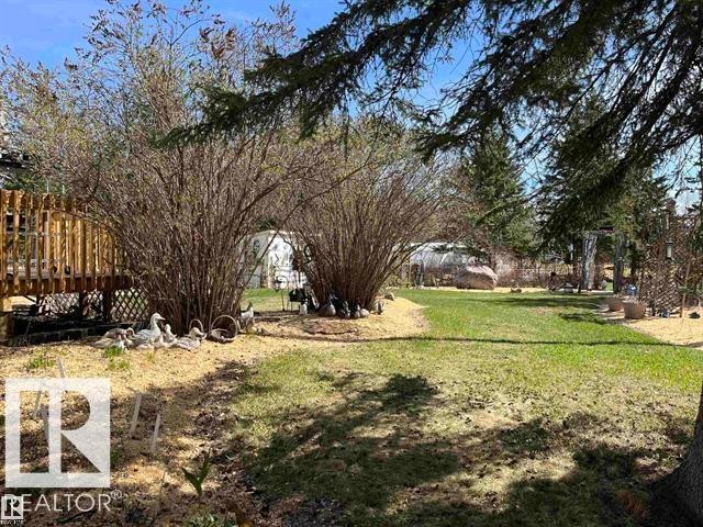 Expansive outdoor space featuring a manicured lawn, established shrubs, and mature trees - 210 55504 Nikoodi Road, Rural Lac Ste. Anne County, AB - Outdoor