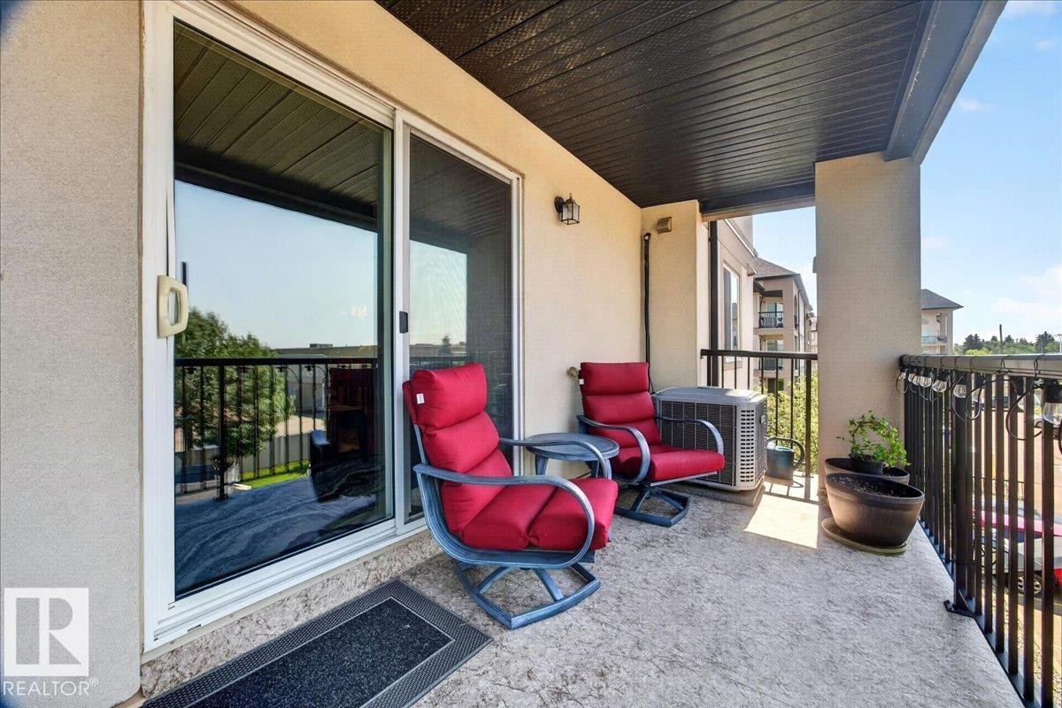 Private balcony featuring concrete flooring, a black railing, and exterior lighting fixtures - #306 13111 140 Av Nw, Edmonton, AB - Outdoor With Exterior