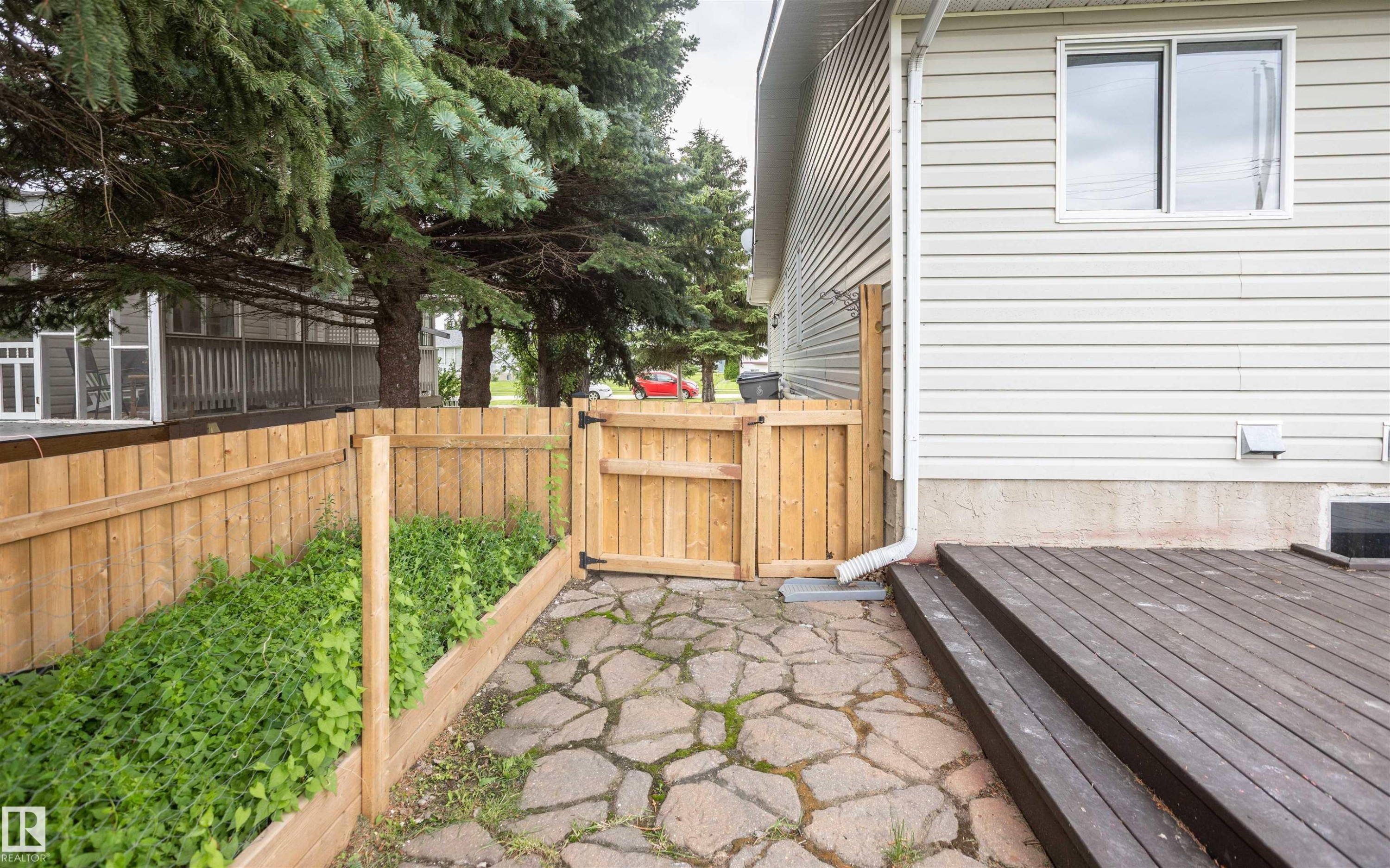 Exterior deck with steps, wood plank fencing, and a flagstone pathway - 5116 51 Avenue, Pickardville, AB - Outdoor