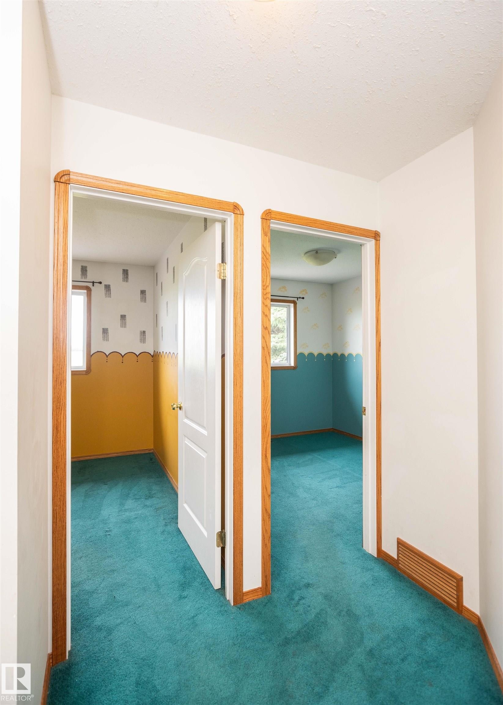 Interior hallway with teal carpet flooring and white walls - 5116 51 Avenue, Pickardville, AB - Indoor Photo Showing Other Room