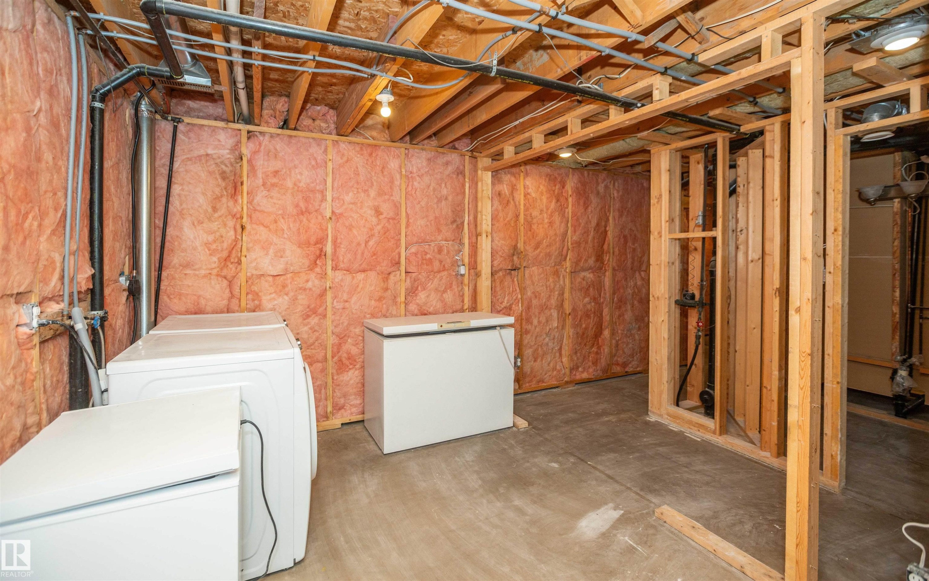 Unfinished basement featuring exposed wood framing and insulation, providing an expansive area for customization - 5116 51 Avenue, Pickardville, AB - Indoor Photo Showing Laundry Room