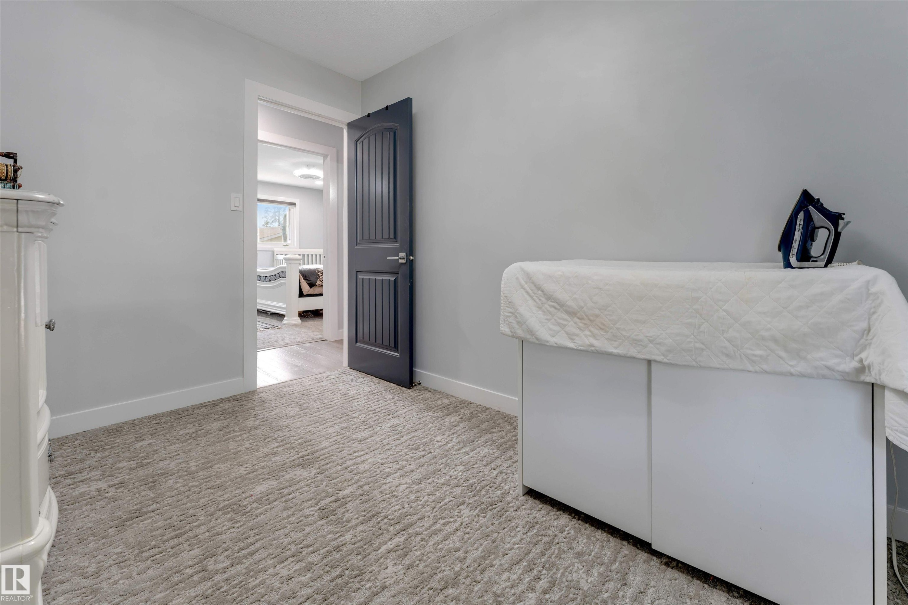 Light gray walls with white baseboards frame a textured gray carpet - 7419 33 Avenue Nw, Edmonton, AB - Indoor Photo Showing Bedroom