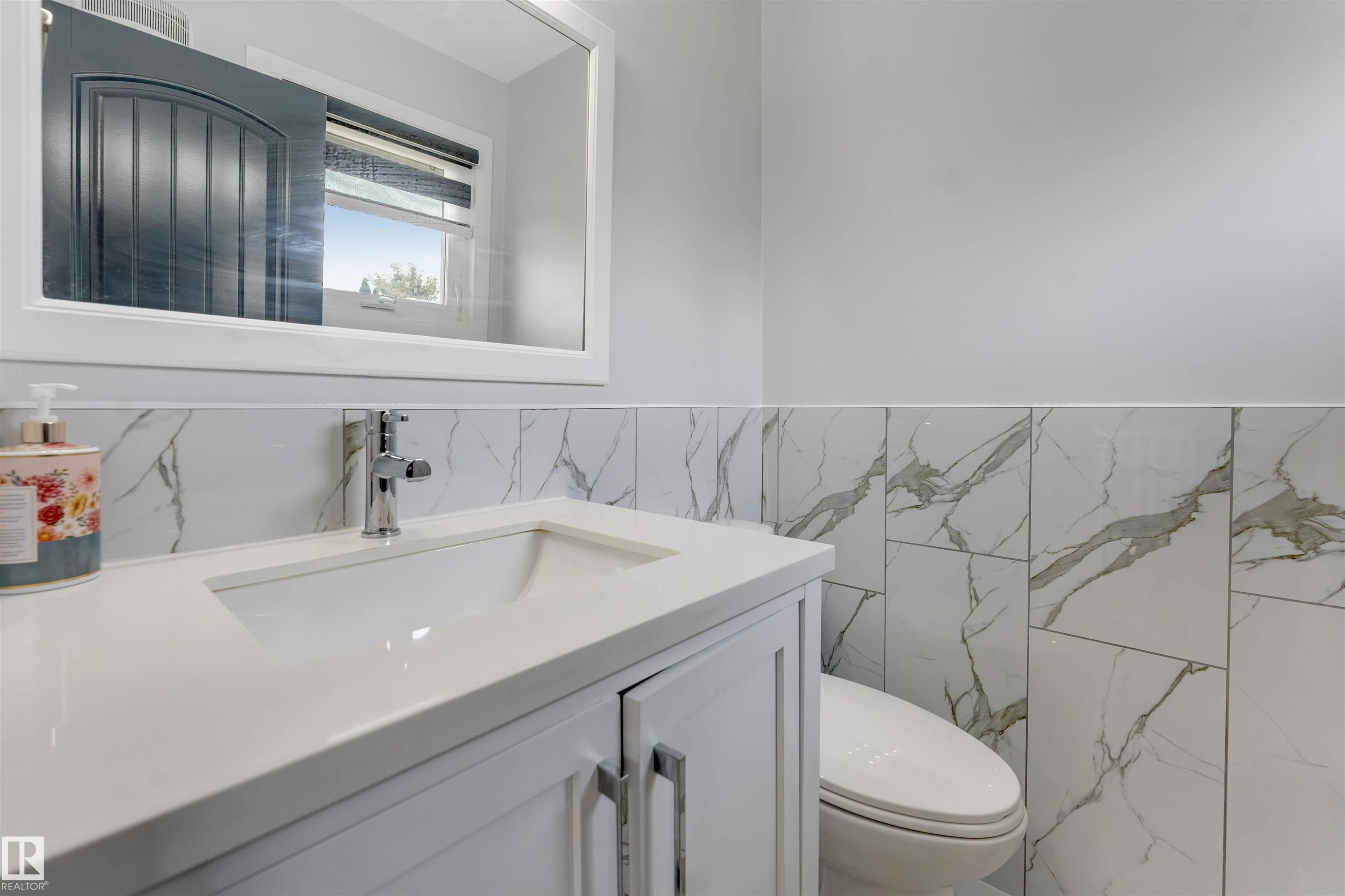 Bathroom vanity with an integrated sink and chrome faucet - 7419 33 Avenue Nw, Edmonton, AB - Indoor Photo Showing Bathroom