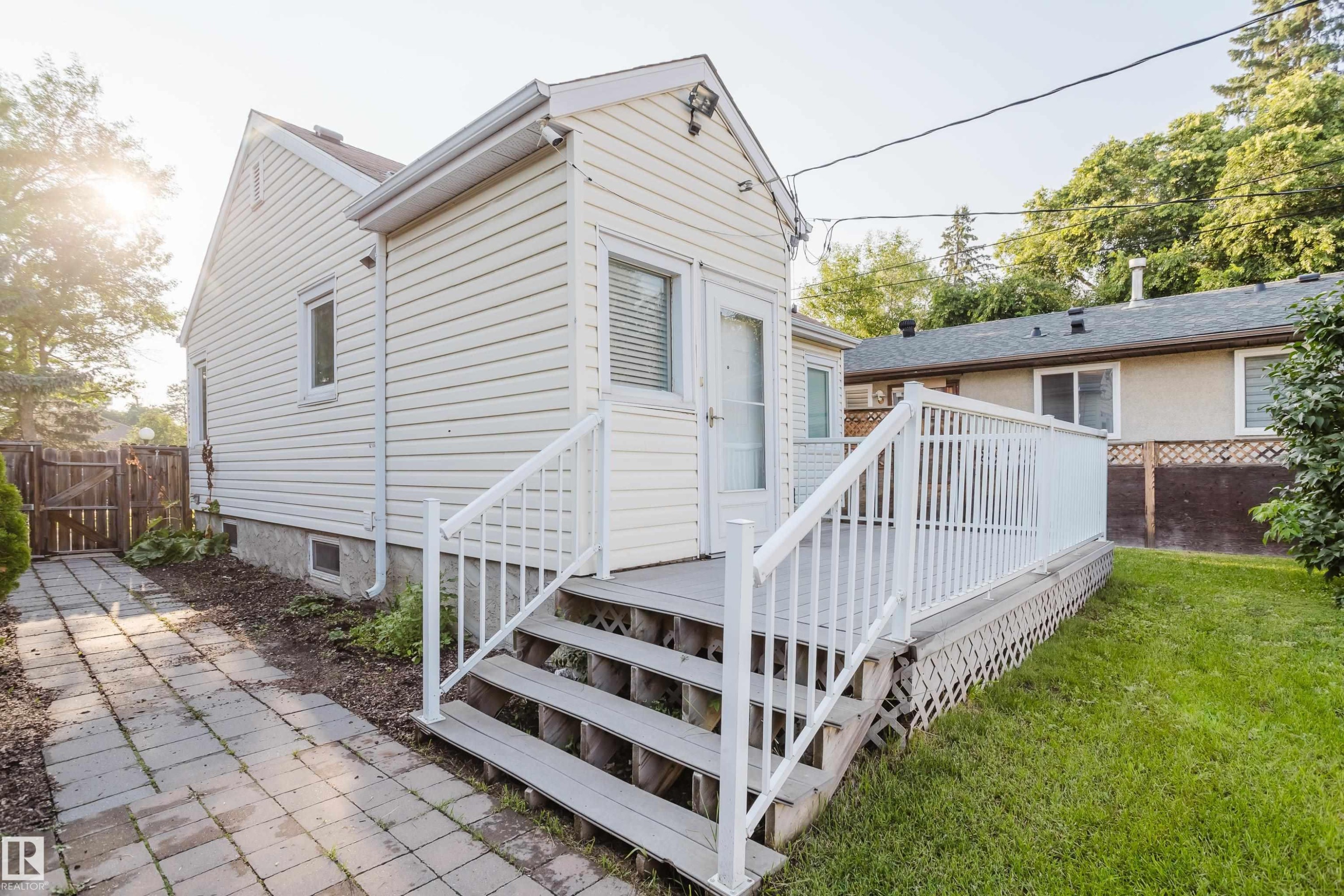Rear exterior featuring white horizontal siding and a matching white deck with railings - 12431 81 Street Nw, Edmonton, AB - Outdoor With Exterior