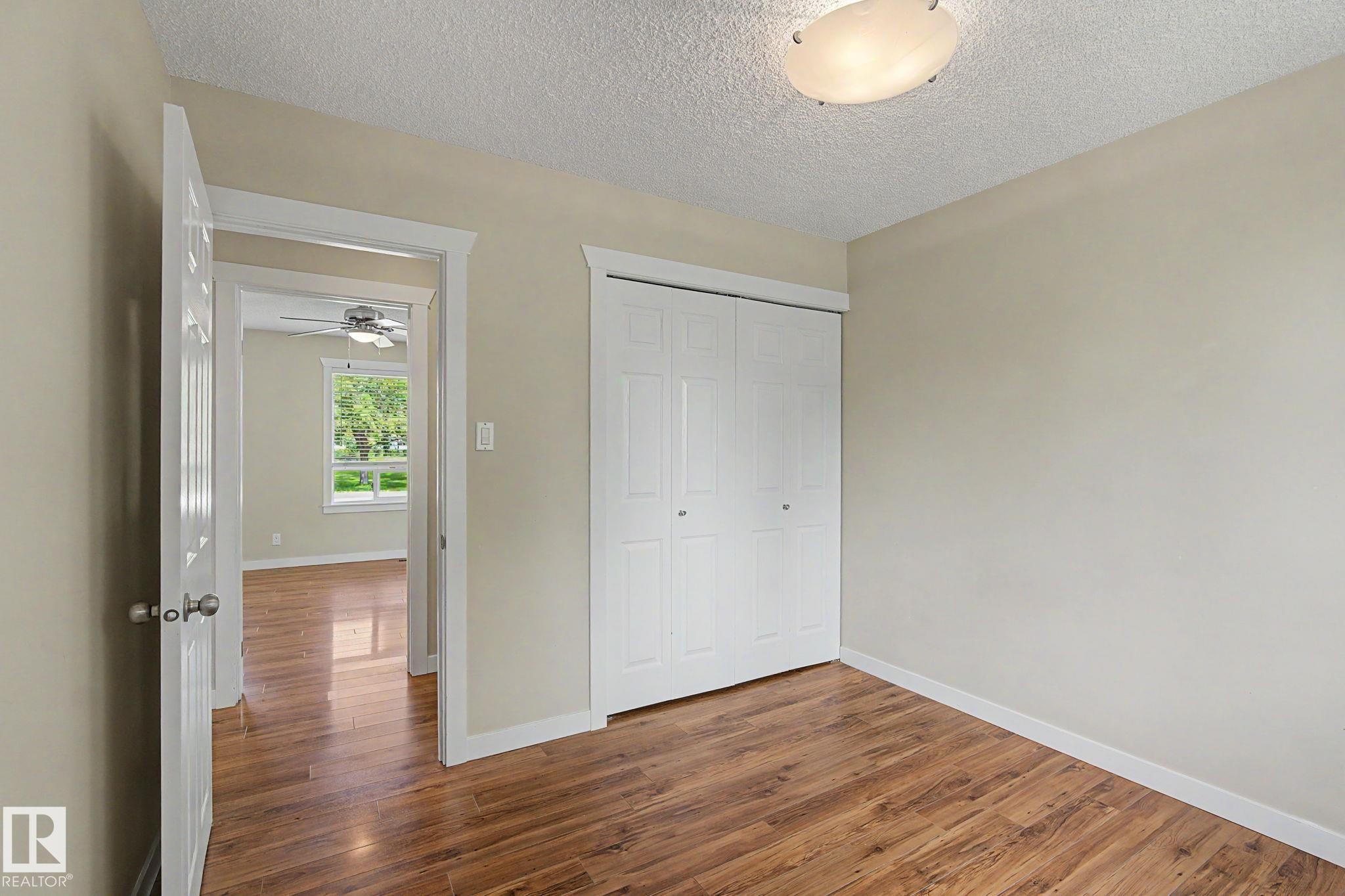 Room featuring wood-finish flooring, neutral wall paint, and white trim - 8823 130A Avenue Nw, Edmonton, AB - Indoor Photo Showing Other Room