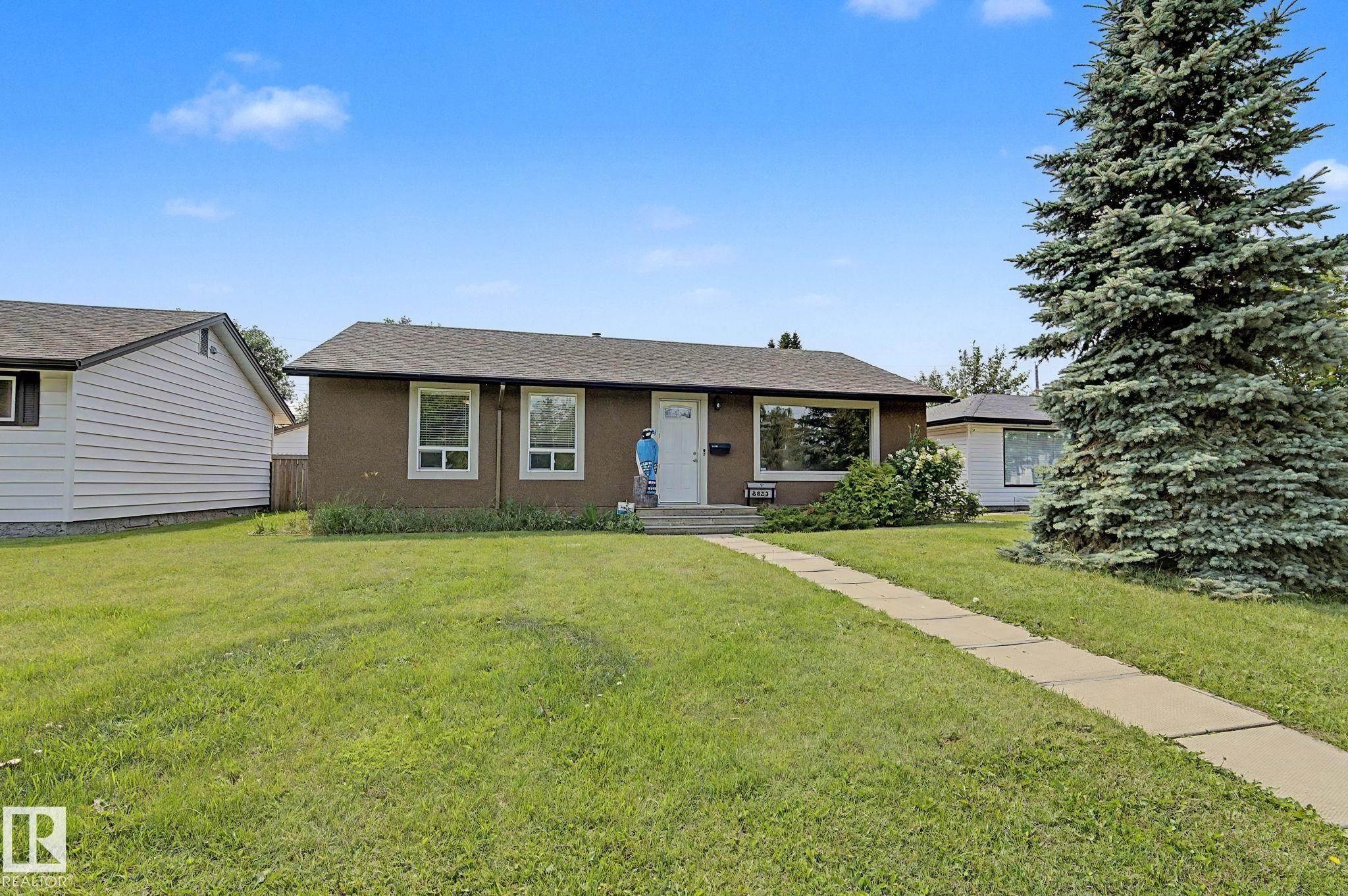 Ranch-style residence featuring a stucco exterior with white trim windows and a dark shingle roof - 8823 130A Avenue Nw, Edmonton, AB - Outdoor