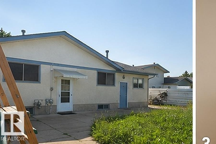 Rear exterior showcasing stucco siding and a blue trim accent - 7812 144 Avenue Nw, Edmonton, AB - Outdoor