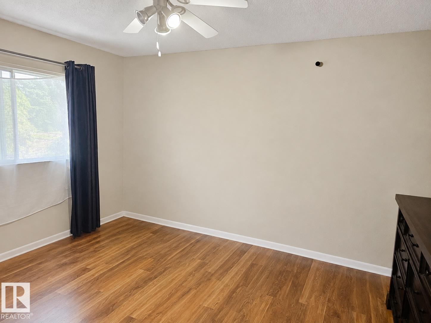 Interior space featuring wood-finish flooring, neutral wall paint, and white baseboards - 7812 144 Avenue Nw, Edmonton, AB - Indoor Photo Showing Other Room