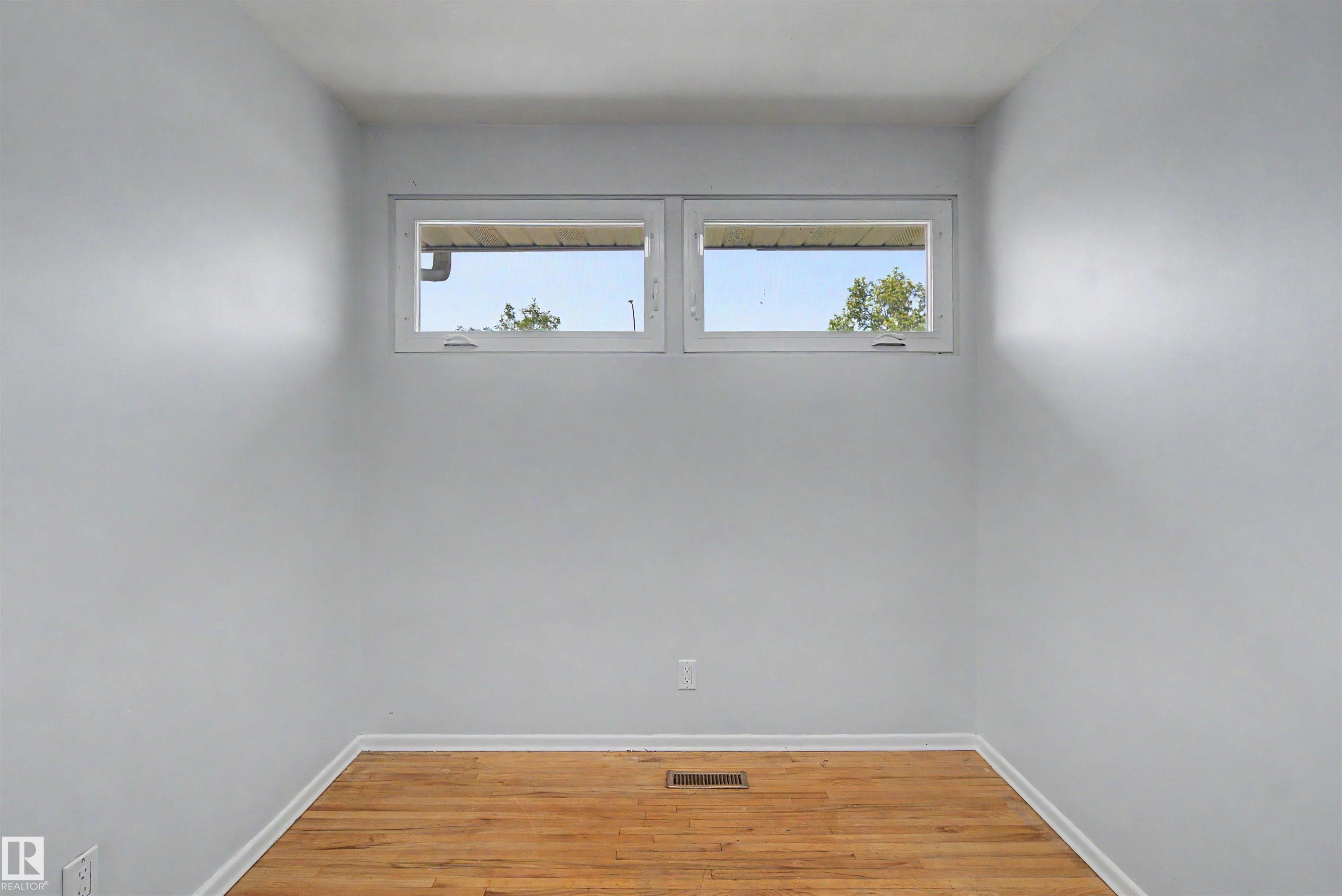 Room with light gray walls, wood-finish flooring, and white baseboards - 8215 149 Street Nw, Edmonton, AB - Indoor Photo Showing Other Room