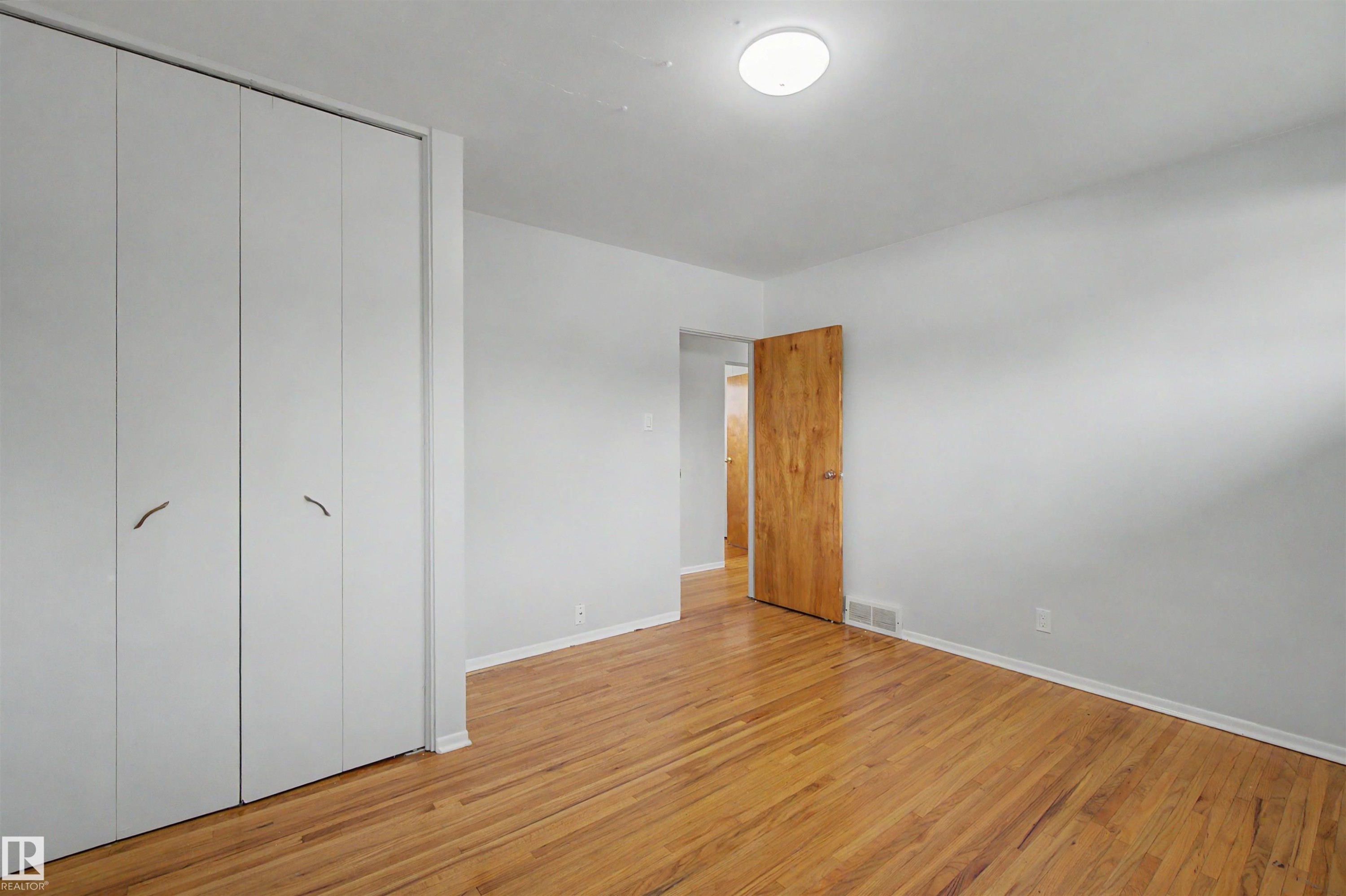 Room featuring wood-finish flooring, white walls, and a ceiling-mounted light fixture - 8215 149 Street Nw, Edmonton, AB - Indoor Photo Showing Other Room
