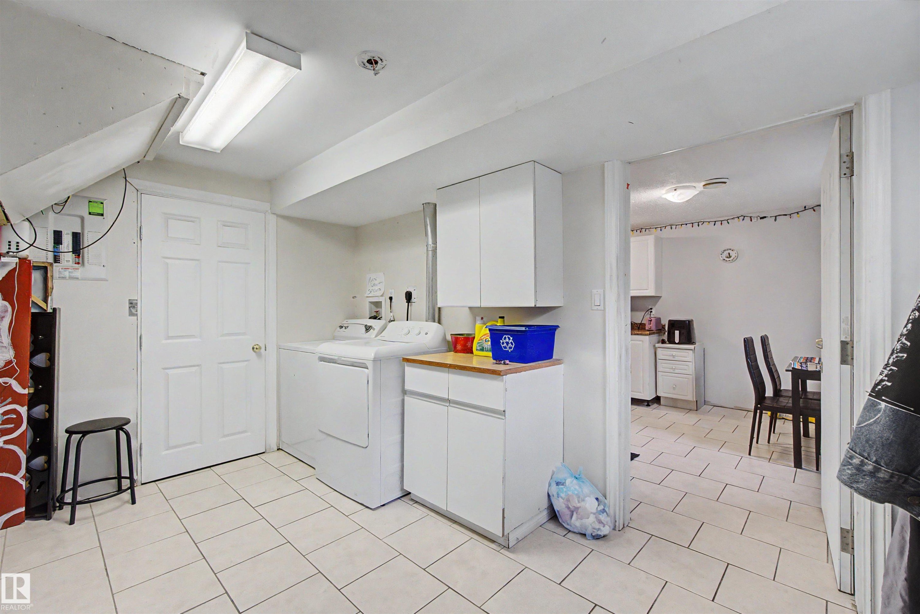 Laundry area featuring a washer, dryer, built-in cabinetry, and wood-finish countertop - 8215 149 Street Nw, Edmonton, AB - Indoor Photo Showing Laundry Room