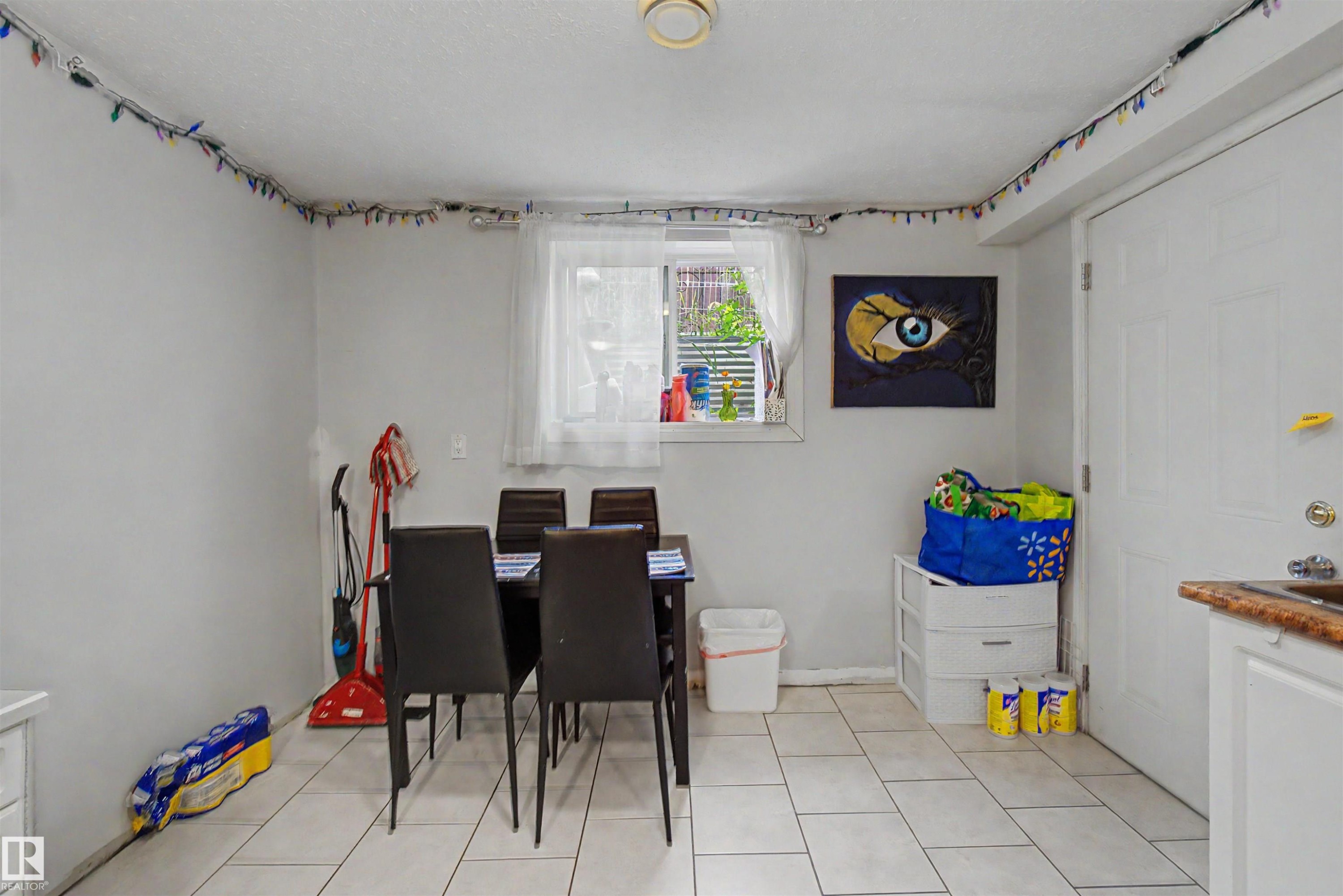 Dining area featuring light-toned tile flooring and a window with natural light - 8215 149 Street Nw, Edmonton, AB - Indoor