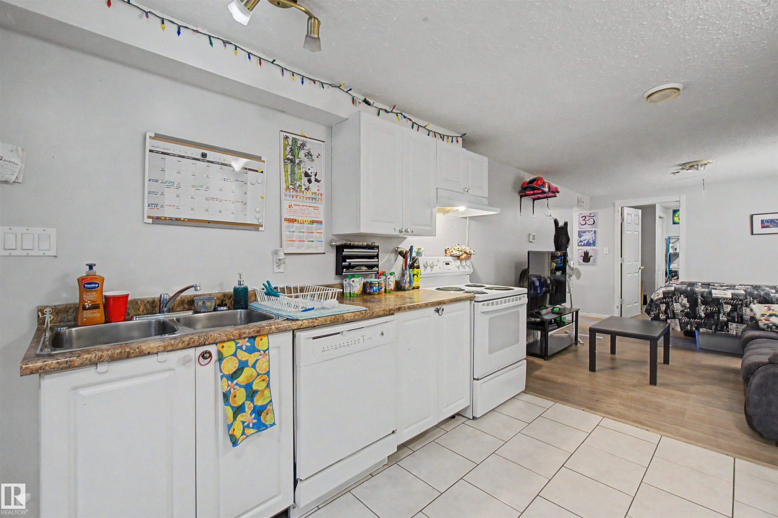 Kitchenette featuring white cabinetry, a double basin sink, and a white electric range - 8215 149 Street Nw, Edmonton, AB - Indoor Photo Showing Kitchen With Double Sink