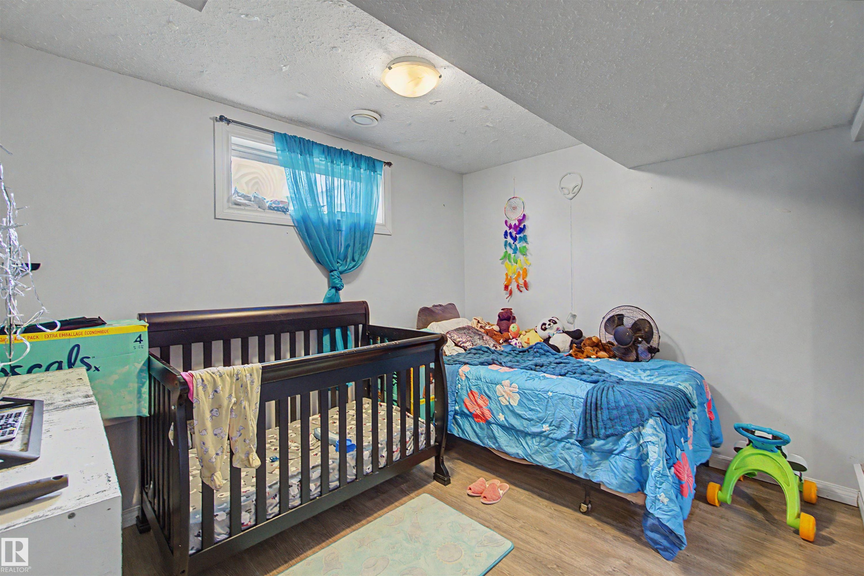 Room featuring a window, wood-finish flooring, and a ceiling-mounted light fixture - 8215 149 Street Nw, Edmonton, AB - Indoor Photo Showing Bedroom