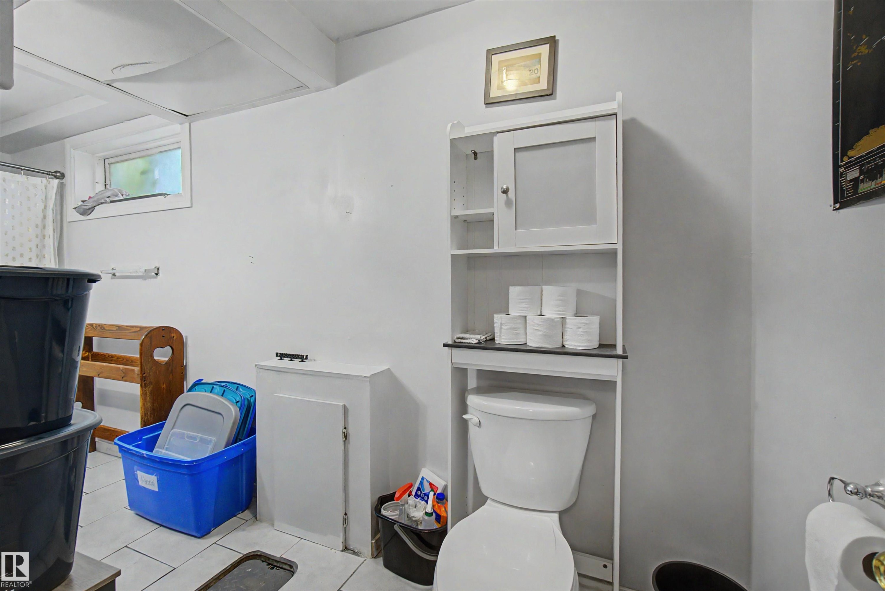 Bathroom featuring a white toilet, white tile flooring, and a white over-the-toilet storage cabinet with a closed door and open shelves - 8215 149 Street Nw, Edmonton, AB - Indoor