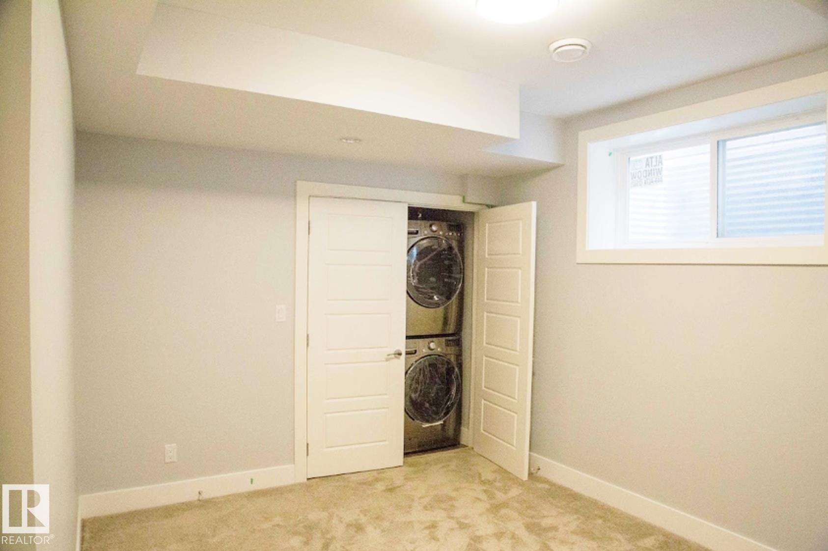 Laundry closet featuring stacked front-load washer and dryer - 1051 174 Street Sw, Edmonton, AB - Indoor