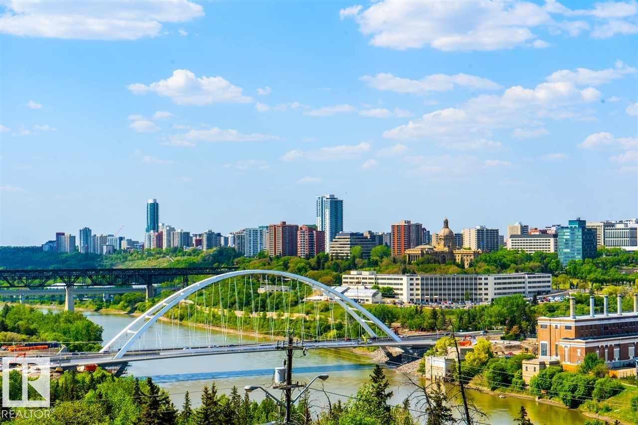 Urban skyline featuring high-rise buildings, a prominent arched bridge spanning a river, and a lush green river valley - #509 10149 Saskatchewan Dr Nw, Edmonton, AB - Outdoor With View
